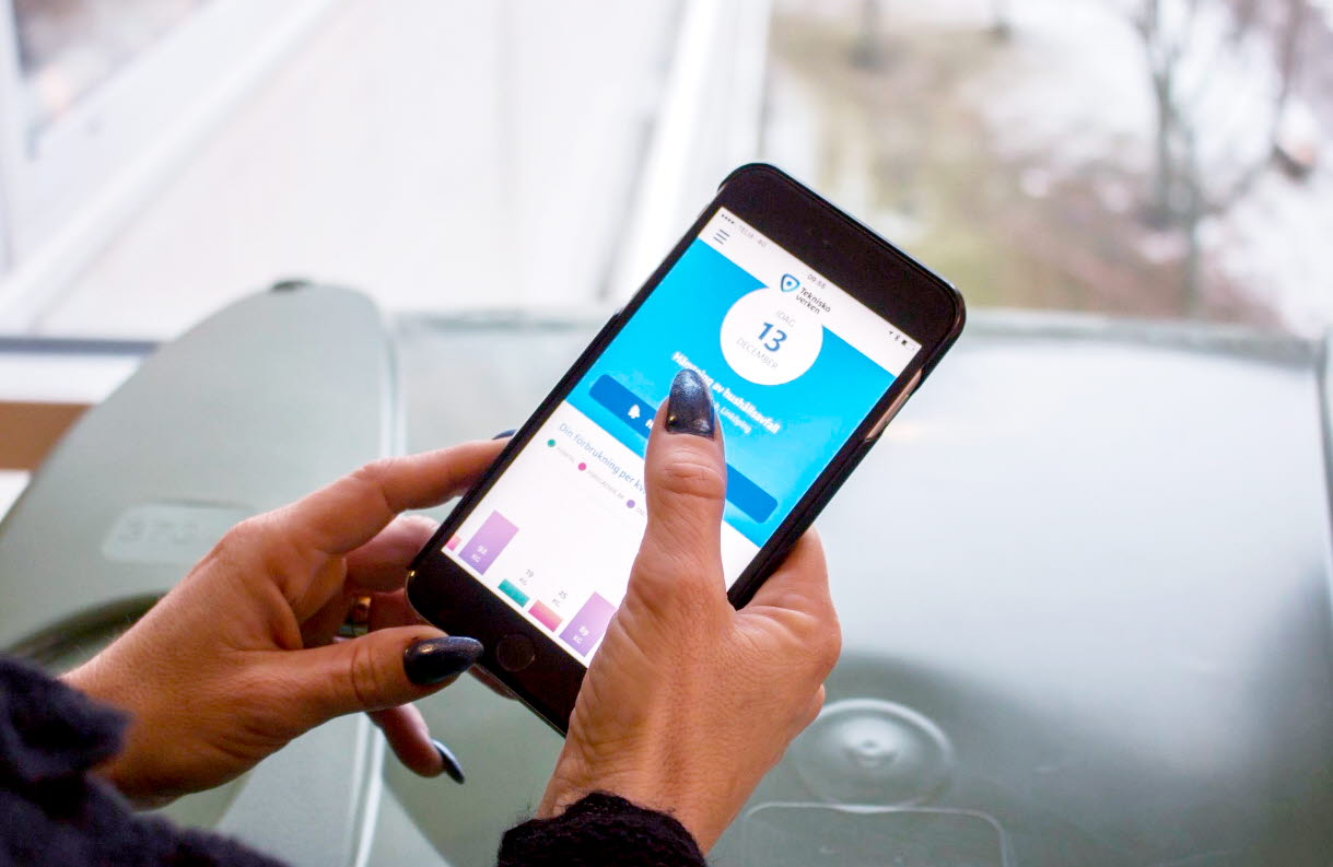 En kvinna har Tekniska verkens app på mobilen. Foto.