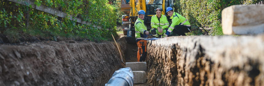 Projektör och entreprenörer tittar på ritning vid grävarbete i Skänninge