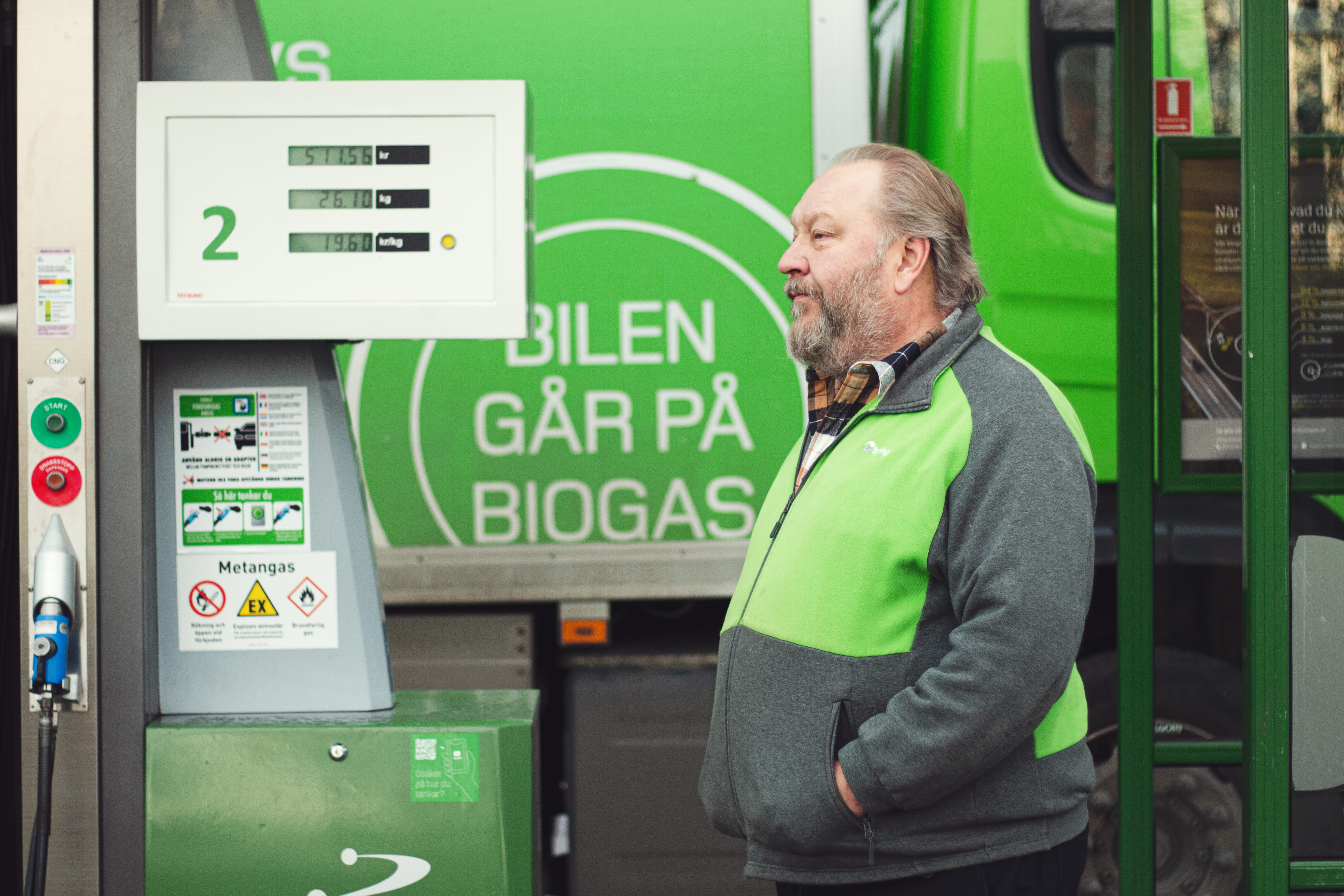 En man står och tankar lastbilen med biogas