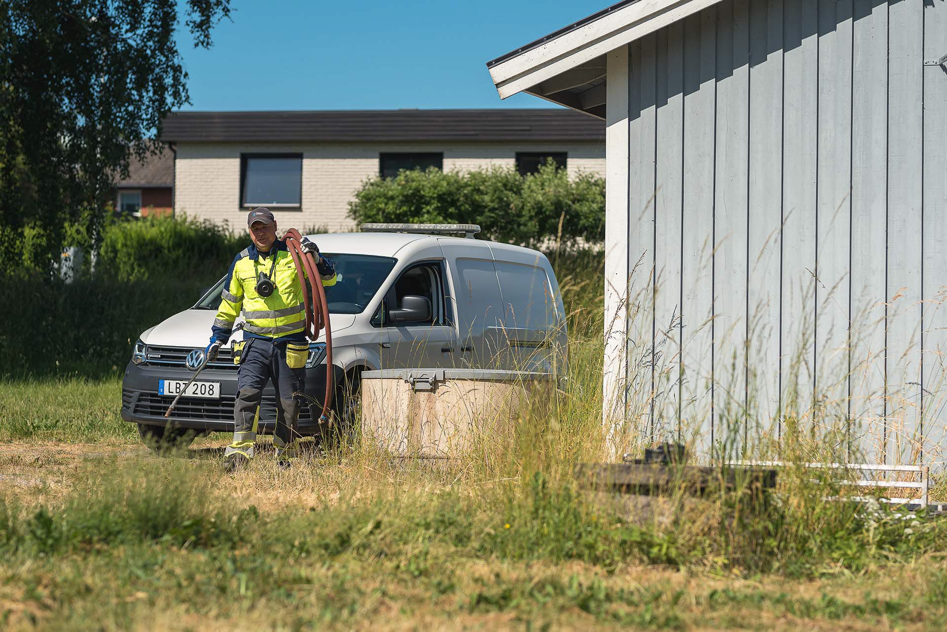 Man i arbetskläder går bort från sin transportbil mot sin arbetsplats