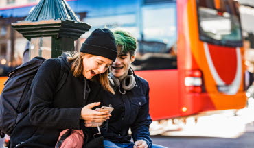 Ungdomar med mobil i stadsmiljö (foto)