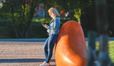 Kund använder mobil på stan i Mjölby