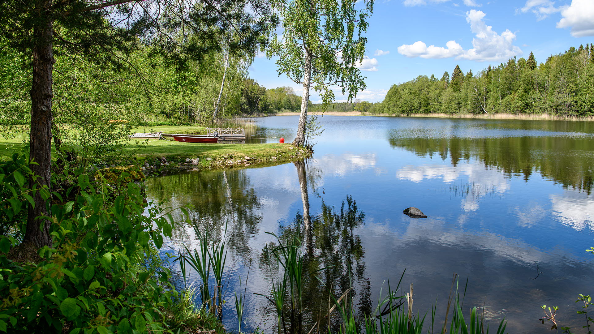 En vacker sjö med en liten båt på våren