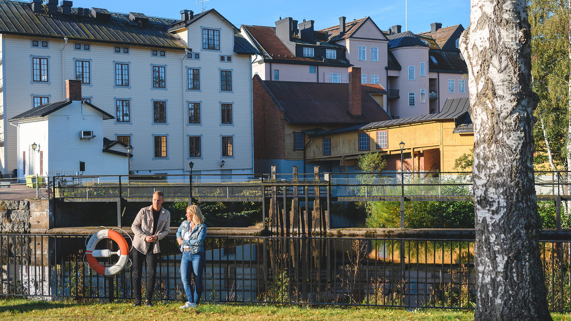 Kunder står och lutar sig mot staket vid Mjölby vattenkraftstation